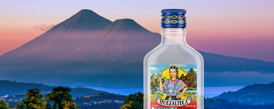 Imagen de botella aguardiente Quezalteca sobre fondo con paisaje de Quetzaltenango. Rediseño de etiqueta por Tridimage.