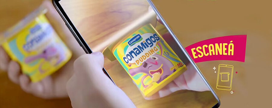 Niño escanea con el smartphone un envase de pudding Conaprole Conamigos para activar una experiencia de realidad aumentada. Proyecto de Tridimage junto a CamOnApp.