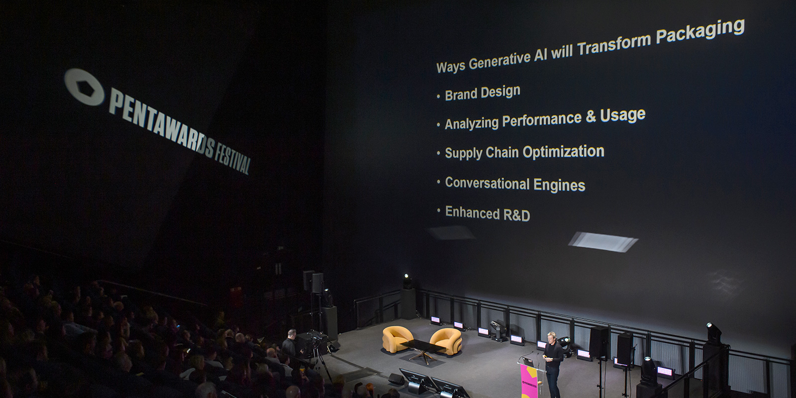 Un hombre en el escenario con una pantalla grande que muestra una lista de formas en que la IA transformará el packaging.