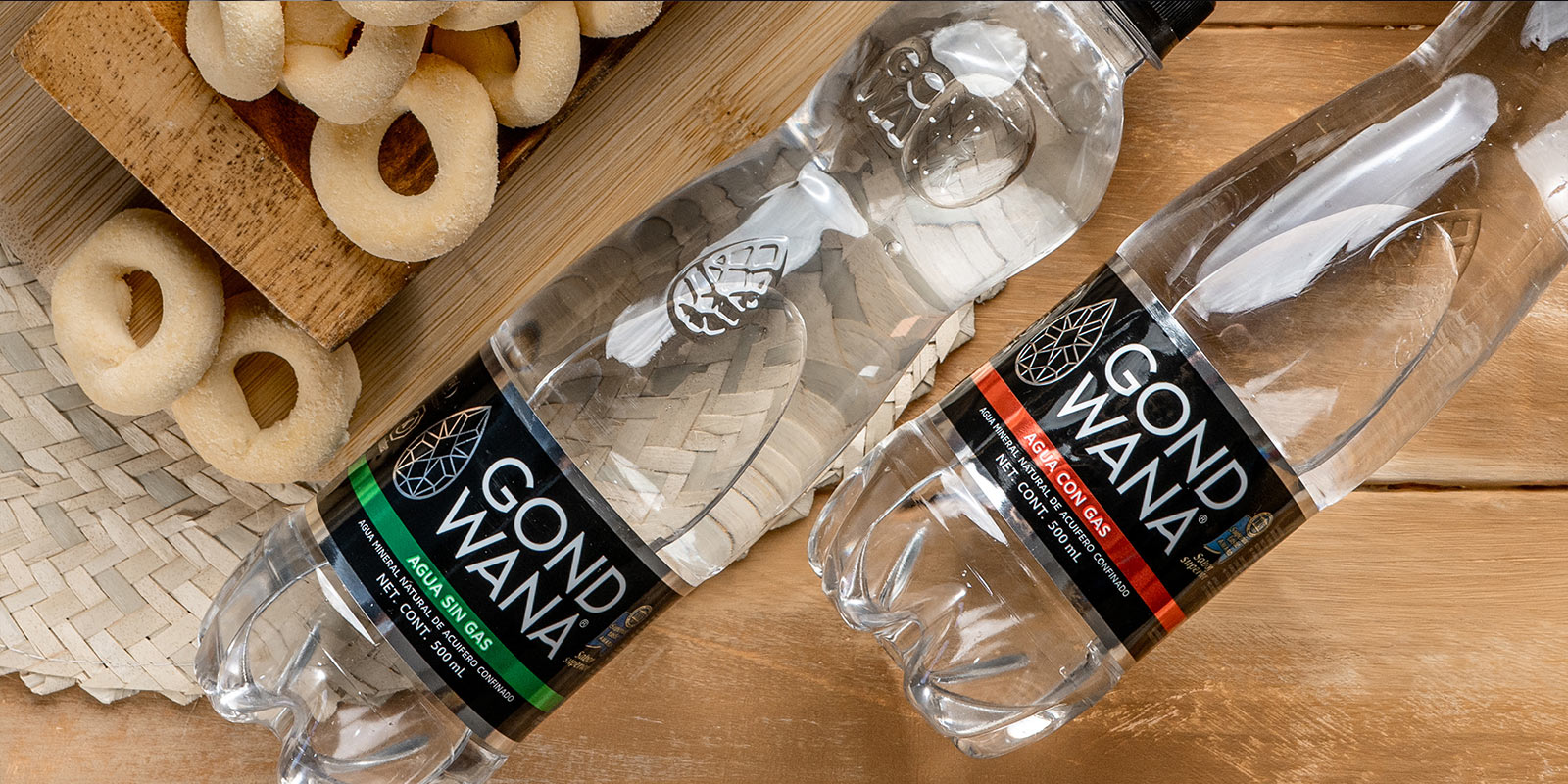 Una botella premium de agua mineral Gond Wana junto a un plato de donas, diseño de packaging por Tridimage.
