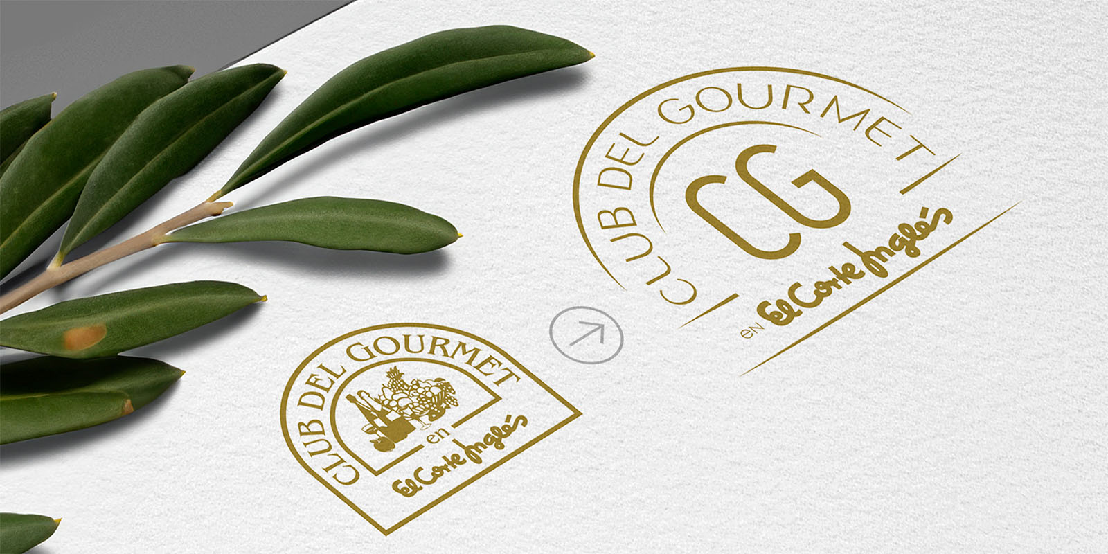 Club del Gourmet: Antes y después del rediseño de logo. Logos en dorado sobre papel blanco. Uno circular con ilustración detallada y texto, el otro más moderno con las iniciales ‘CG’ al centro. Ambos indican la asociación con El Corte Inglés.