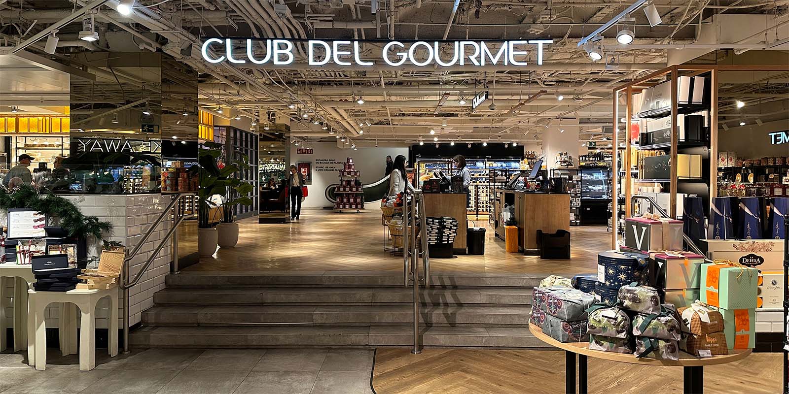 Club del Gourmet: Vista del interior de la tienda con iluminación acogedora y decoración elegante.
