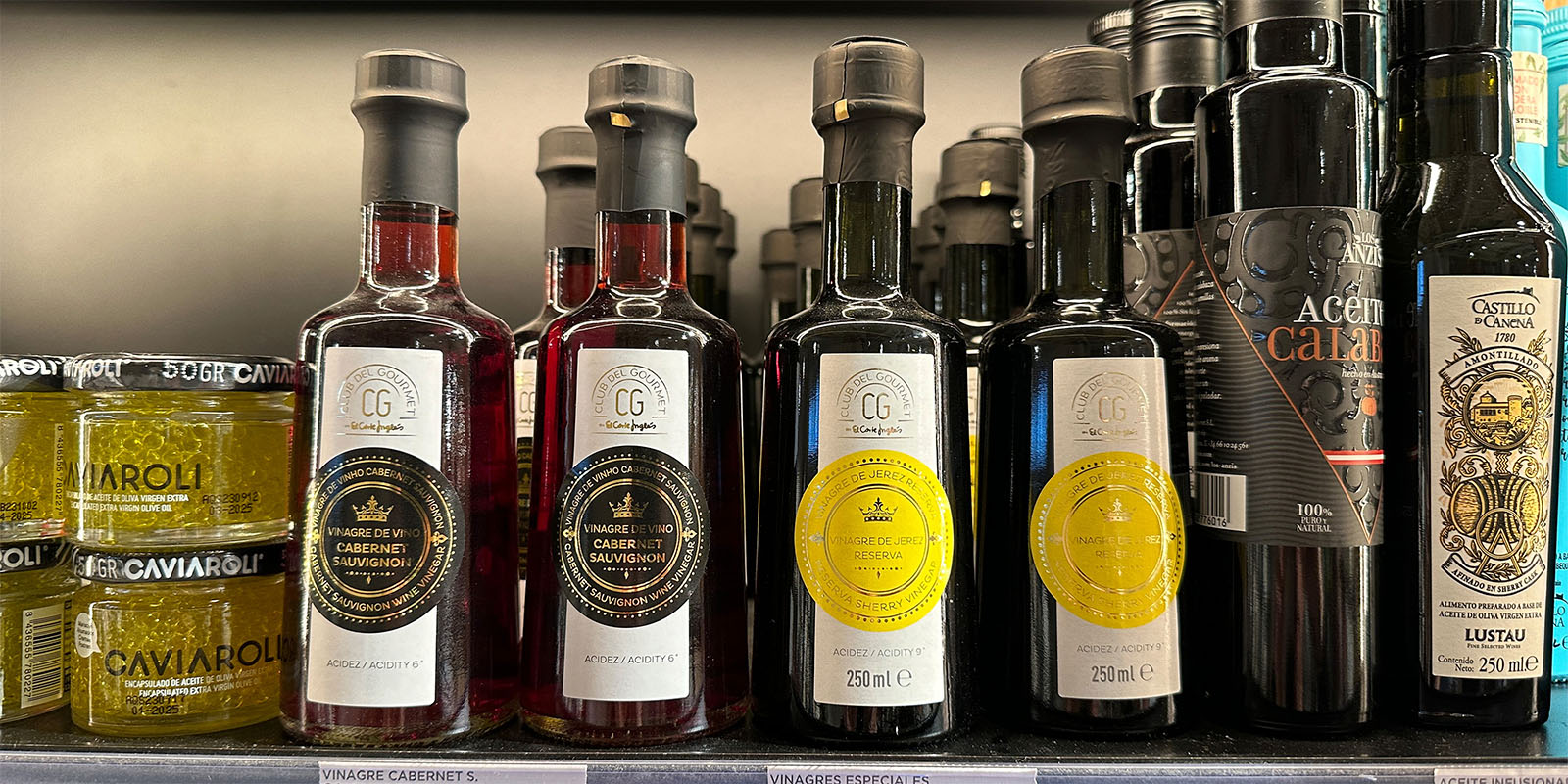 Club del Gourmet: Variedad de botellas de vinagre en góndola junto a otros productos similares, diseño de Tridimage.