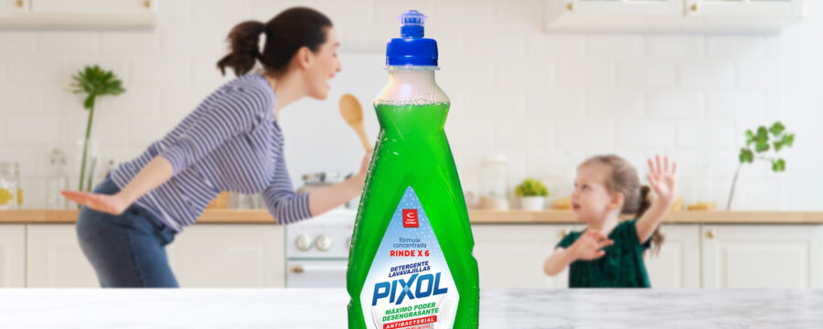 Madre e hija cantan alegremente en la cocina. Una botella de detergente Pixol color verde se destaca en primer plano. Diseño por Tridimage.