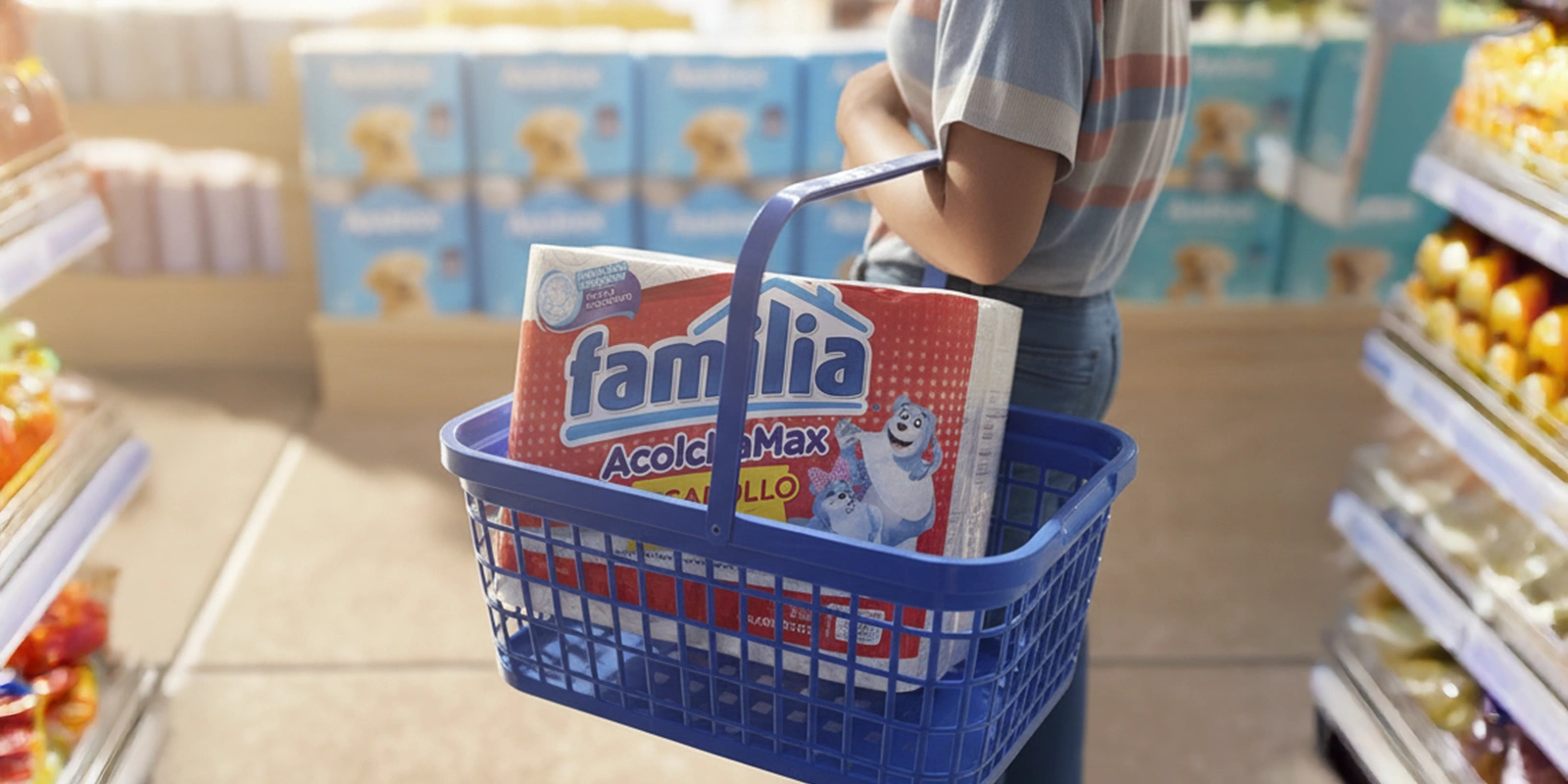 Primer plano de una canasta de supermercado azul con un paquete de papel higiénico Familia adentro.