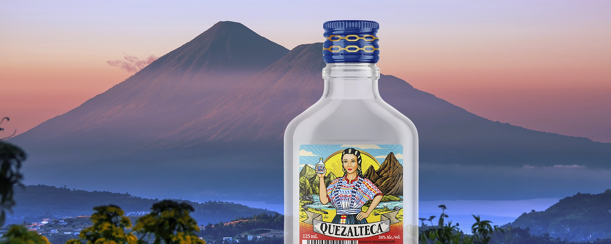 Imagen de botella aguardiente Quezalteca sobre fondo con paisaje de Quetzaltenango. Rediseño de etiqueta por Tridimage.