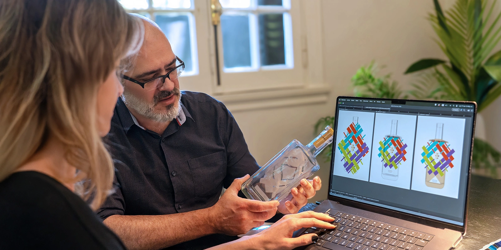 Diseñadores de Tridimage evaluando el prototipo de botella de Tequila Diversa junto a un modelo 3D en computadora.