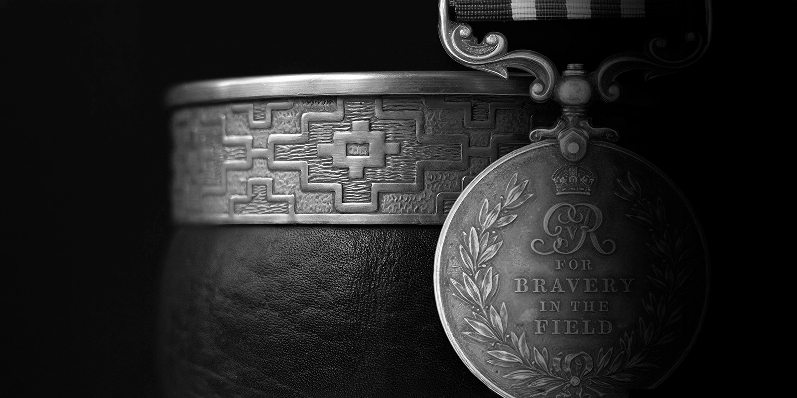 Medalla de valentía y grabado ancestral en plata, inspiración conceptual para el packaging premium Argintum.